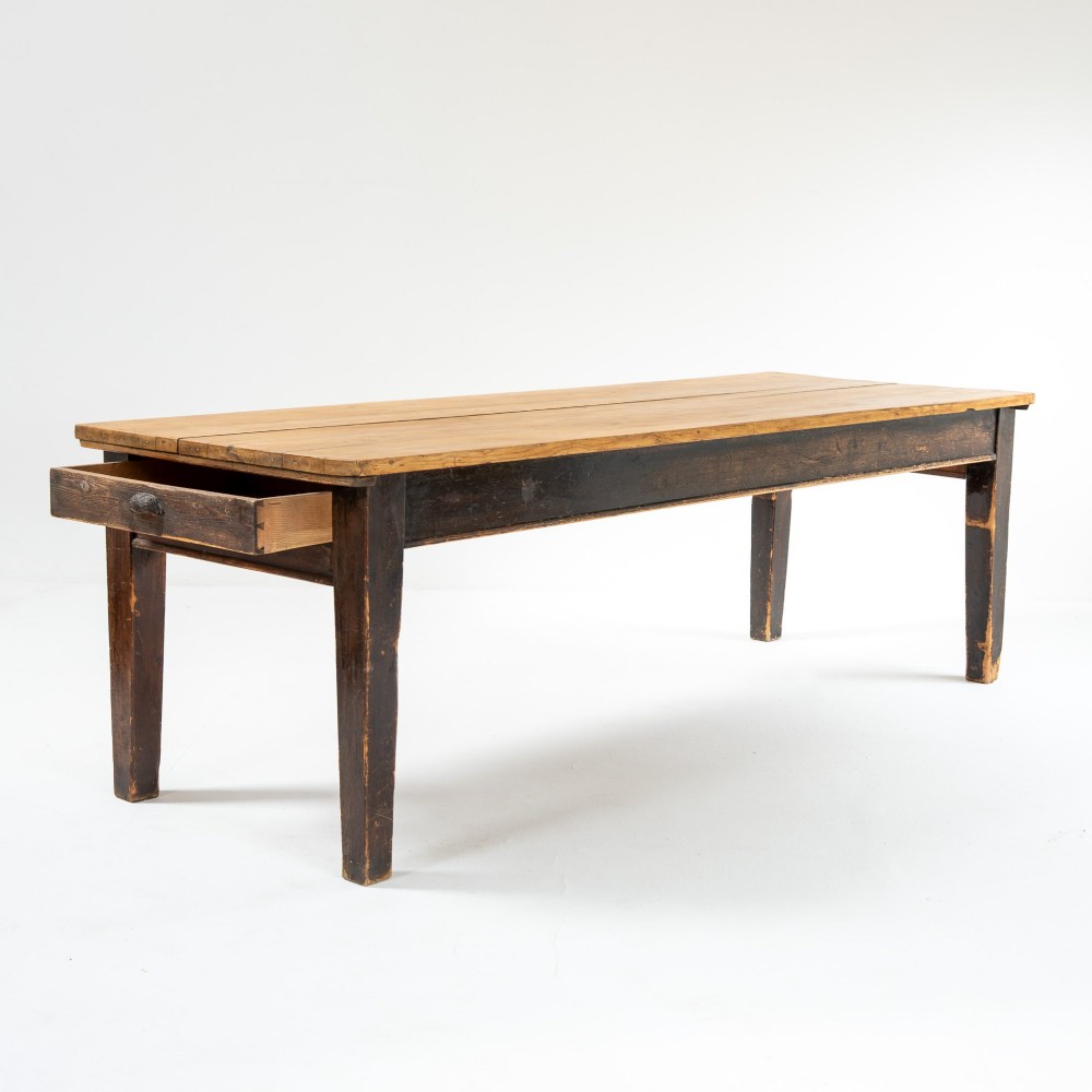 An eight-foot long Victorian pine harvest table featuring a natural timber top surface, a distressed black painted apron, and tapered square legs. View IV