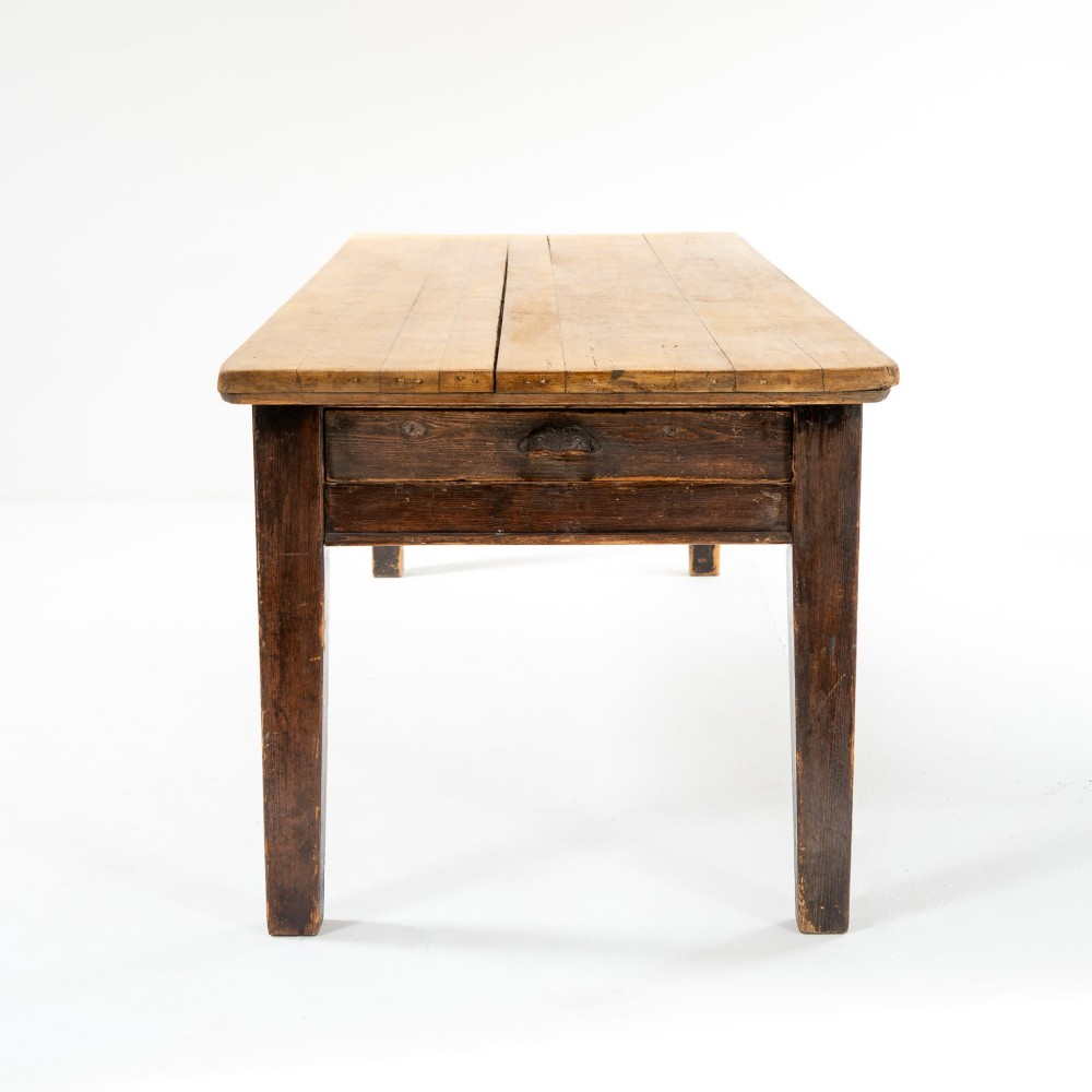 An eight-foot long Victorian pine harvest table featuring a natural timber top surface, a distressed black painted apron, and tapered square legs. View V