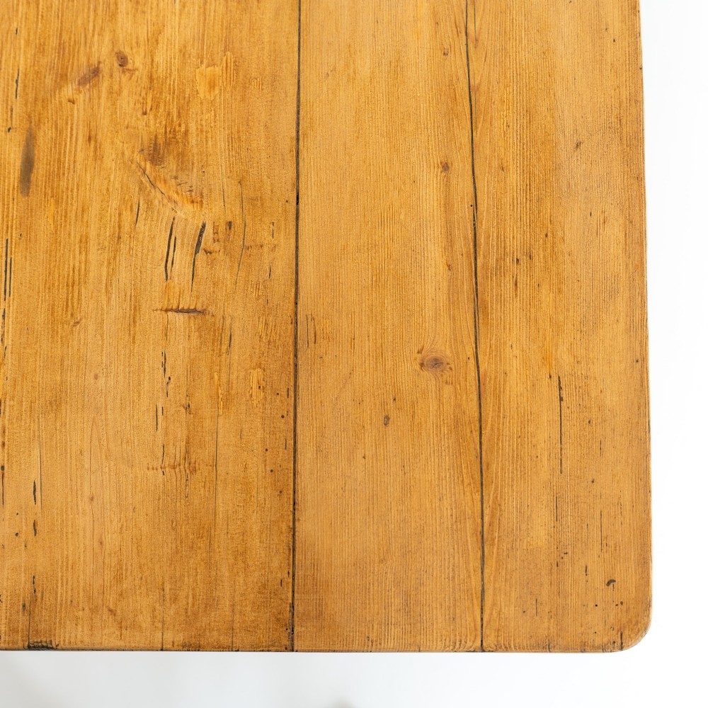 An eight-foot long Victorian pine harvest table featuring a natural timber top surface, a distressed black painted apron, and tapered square legs. View XI