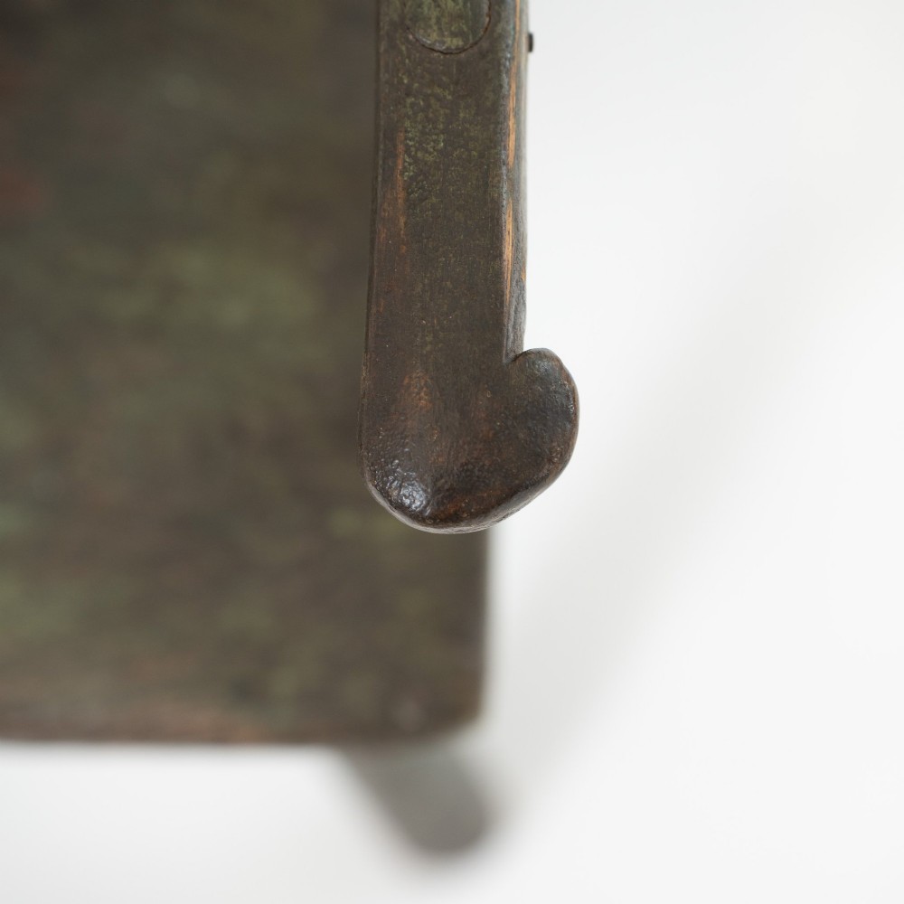 A 19th-century primitive childs stick-back armchair crafted from dark patinated timber with splayed legs and a crest rail. View VI