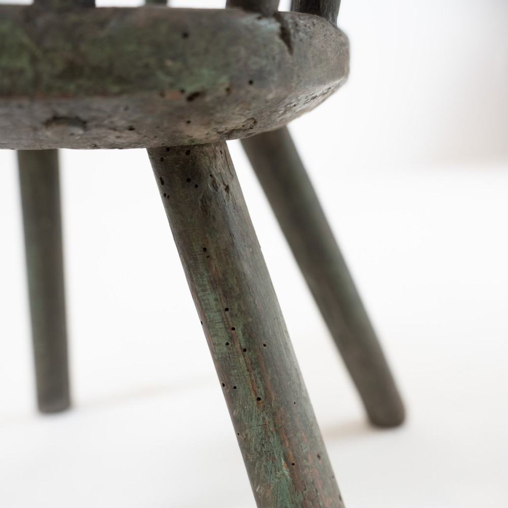 A 19th-century primitive childs stick-back armchair crafted from dark patinated timber with splayed legs and a crest rail. View XI