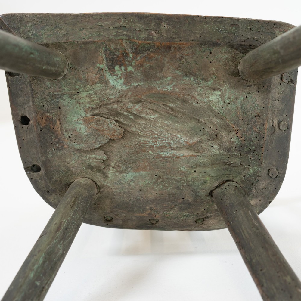 A 19th-century primitive childs stick-back armchair crafted from dark patinated timber with splayed legs and a crest rail. View XIII