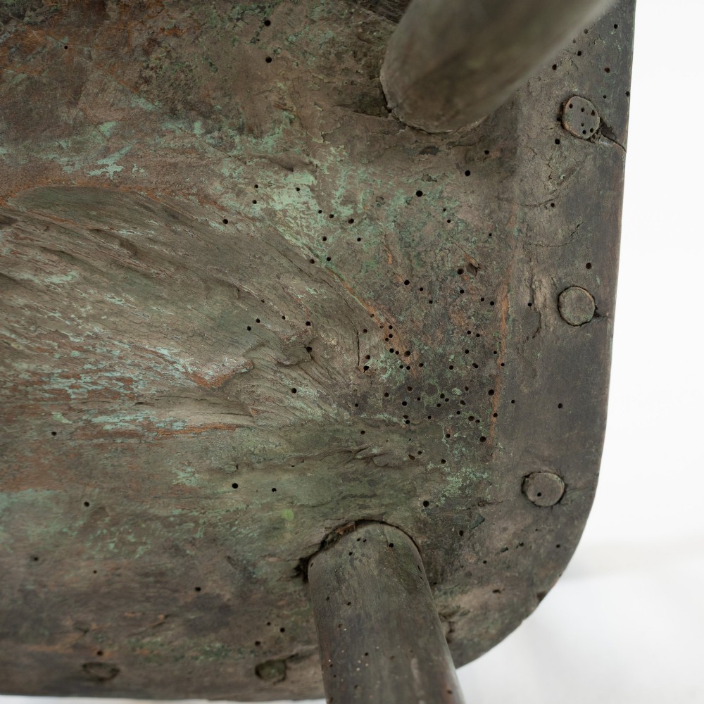 A 19th-century primitive childs stick-back armchair crafted from dark patinated timber with splayed legs and a crest rail. View XIV