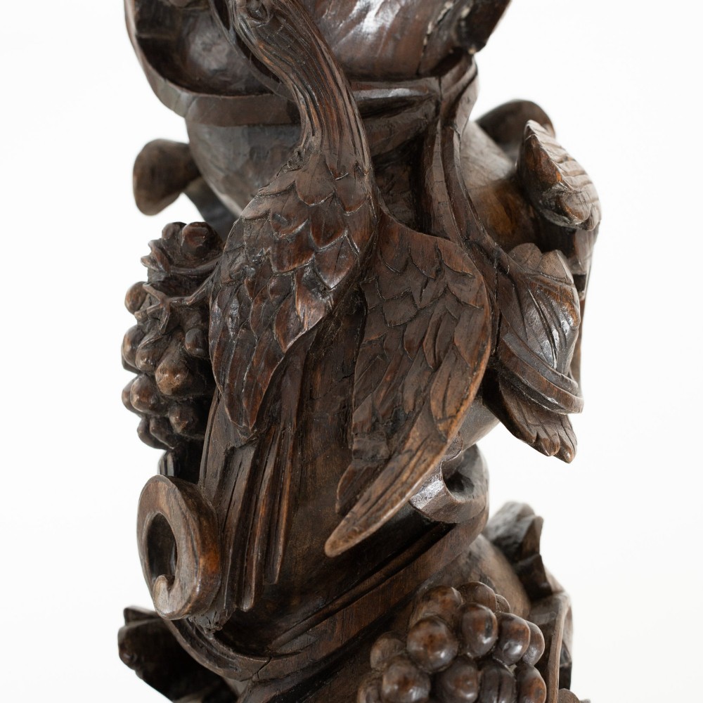 A dark carved oak Solomonic pedestal column with a spiralled grapevine shaft, Corinthian capital, and stepped square base. View V