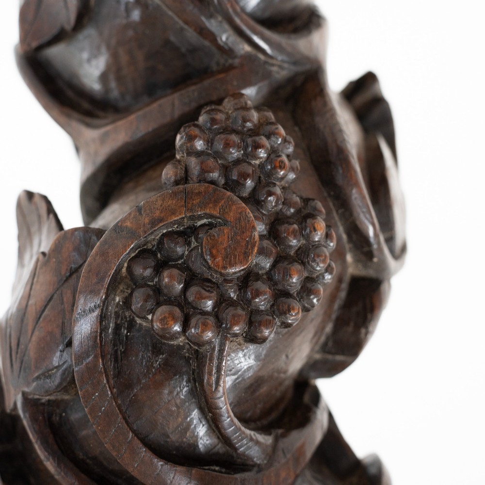 A dark carved oak Solomonic pedestal column with a spiralled grapevine shaft, Corinthian capital, and stepped square base. View VII