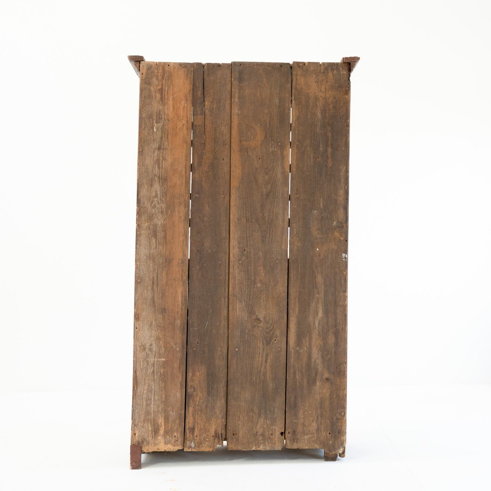 A late eighteenth-century dark timber Irish kitchen dresser featuring open plate shelves with scalloped sides above a single-door cupboard base with wrought iron hinges. View IV
