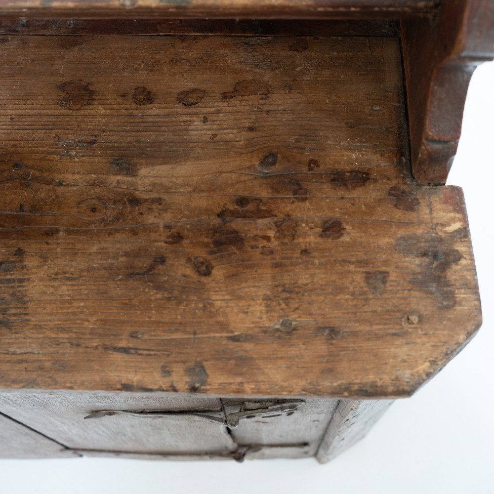 A late eighteenth-century dark timber Irish kitchen dresser featuring open plate shelves with scalloped sides above a single-door cupboard base with wrought iron hinges. View VIII