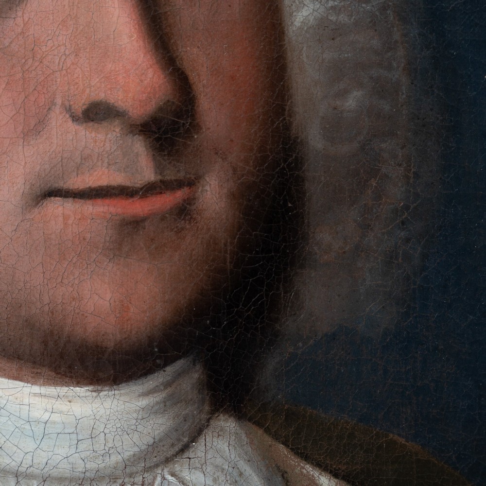 An 18th-century oil portrait on canvas depicting a gentleman in a powdered wig, white cravat, and draped brown mantle, presented in an ornate gilt frame. View IV
