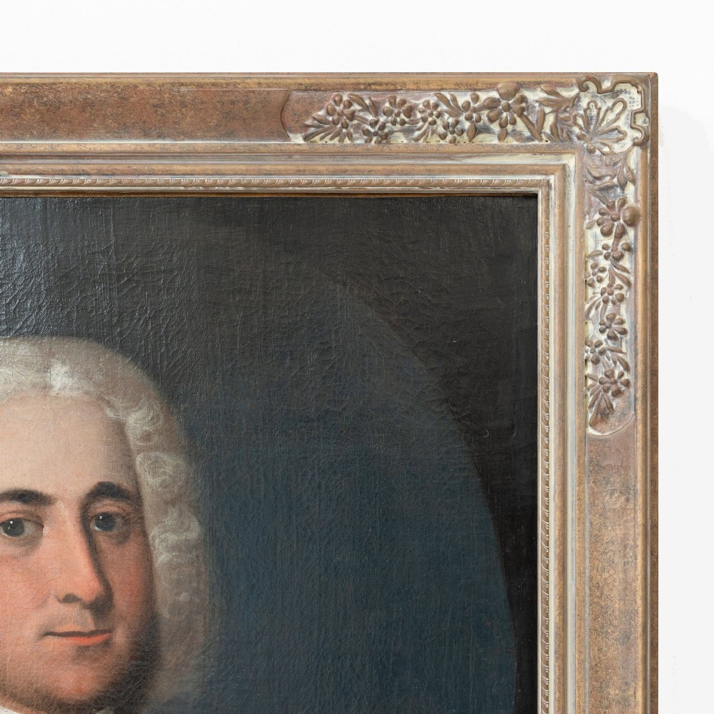 An 18th-century oil portrait on canvas depicting a gentleman in a powdered wig, white cravat, and draped brown mantle, presented in an ornate gilt frame. View VII