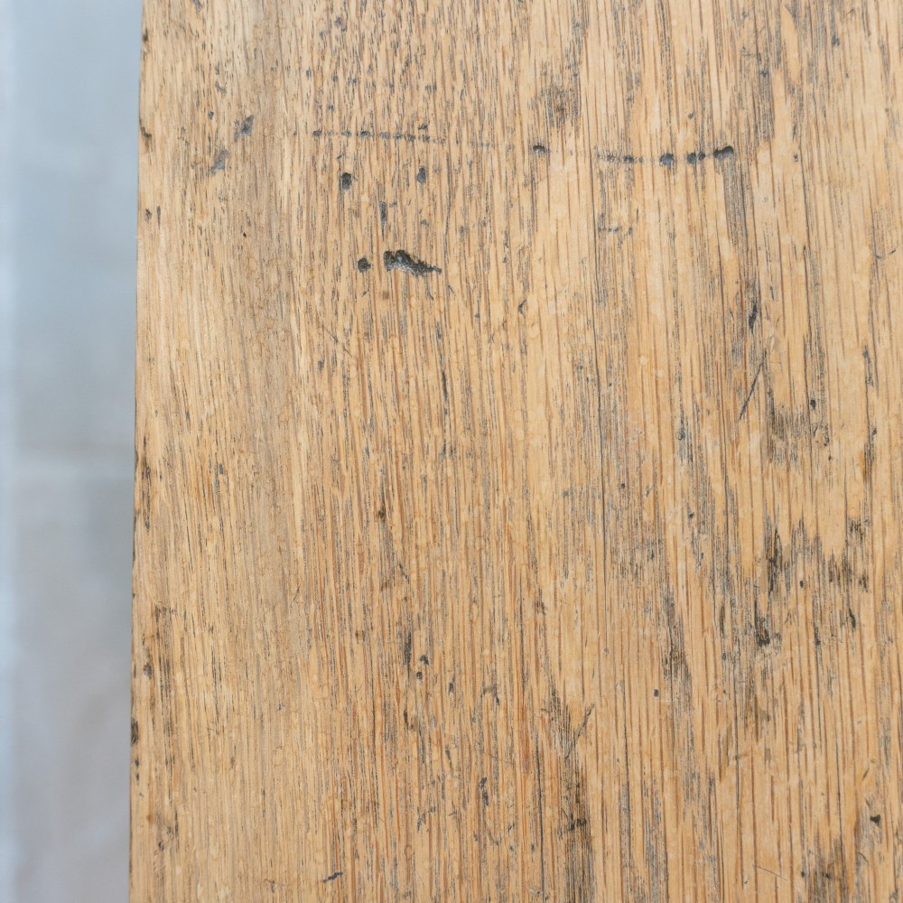 A long English oak refectory bench featuring a rectangular seat supported by three slab legs connected by a low central stretcher. View VII