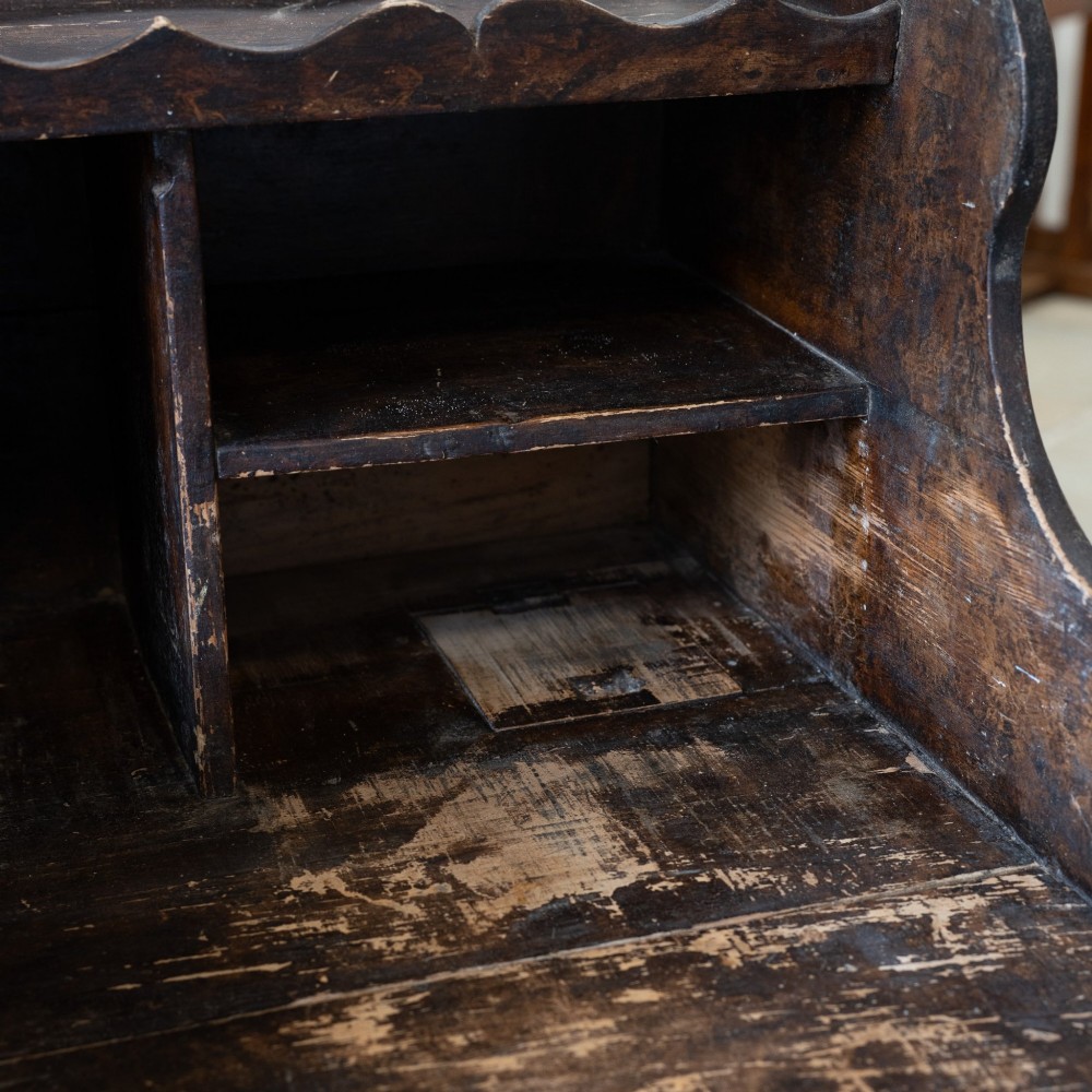 A dark brown antique French provincial clerk desk featuring a scalloped gallery back, pigeonholes, small interior drawers, and square tapered legs. View IX
