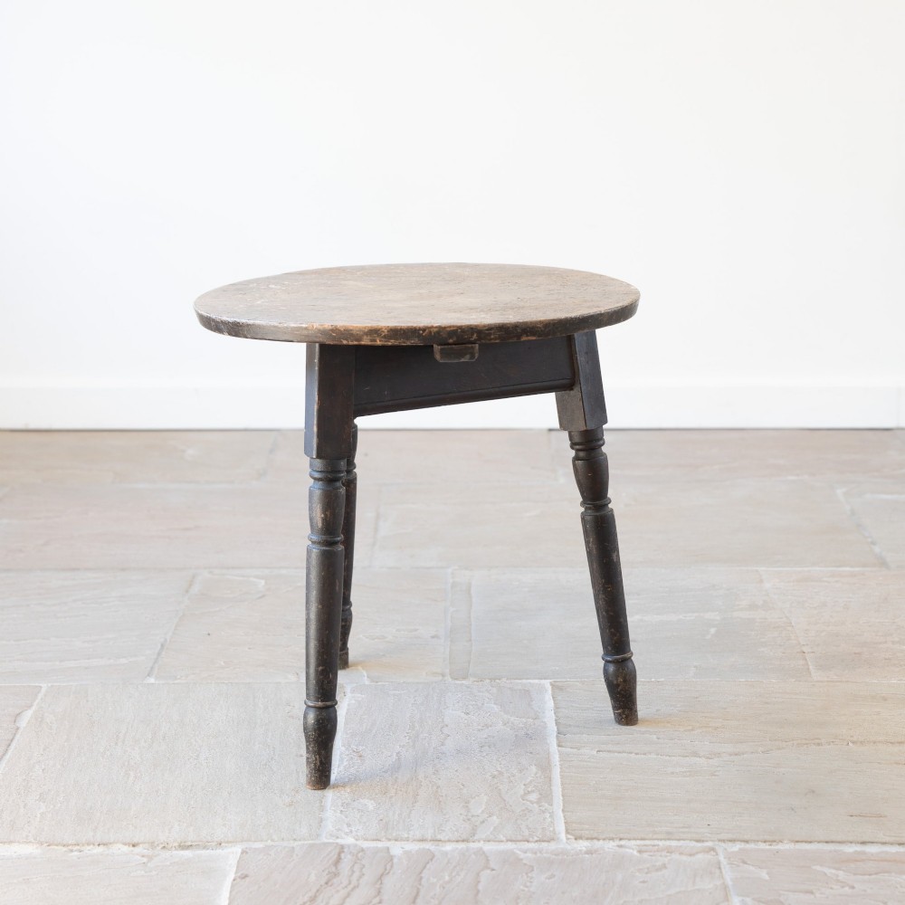 An English nineteenth-century dark brown wooden cricket table featuring a circular top and three turned legs. View III