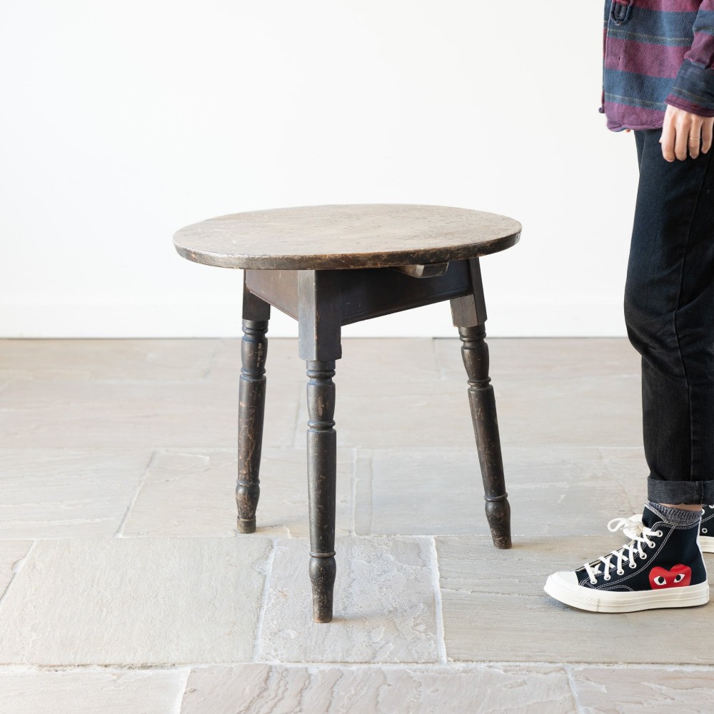 An English nineteenth-century dark brown wooden cricket table featuring a circular top and three turned legs. View IV