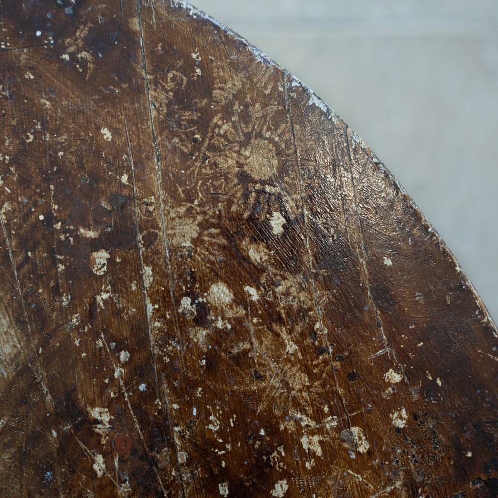 An English nineteenth-century dark brown wooden cricket table featuring a circular top and three turned legs. View V