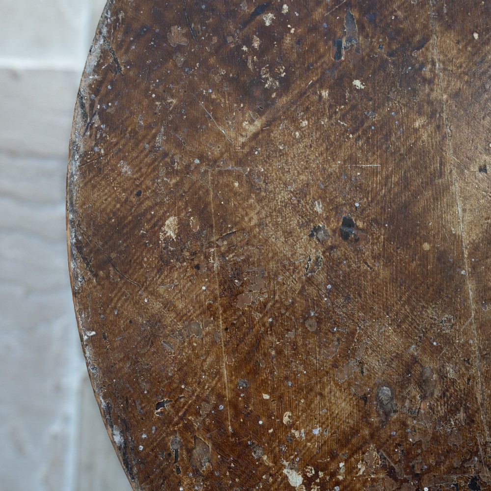 An English nineteenth-century dark brown wooden cricket table featuring a circular top and three turned legs. View VII