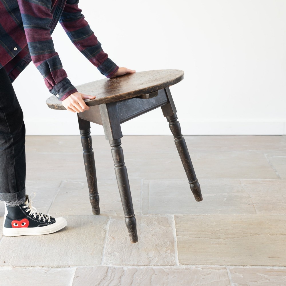 An English nineteenth-century dark brown wooden cricket table featuring a circular top and three turned legs. View IX