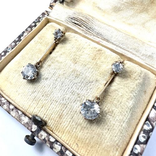 fig 1. A pair of 9ct yellow gold drop earrings featuring round white zircons held in claw settings.
