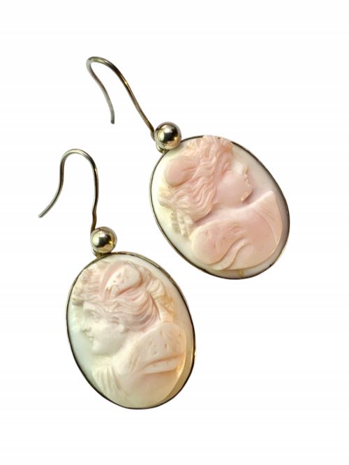 fig 1. A pair of oval drop earrings featuring carved pink and white queen conch shell cameos depicting classical profile portraits set in silver mounts.