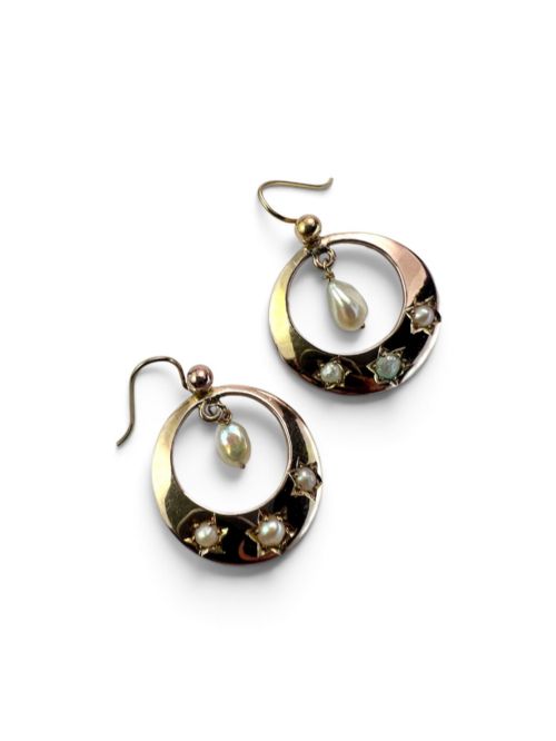 fig 1. A pair of yellow gold Victorian crescent drop earrings featuring star-set seed pearls and a suspended central pearl drop.