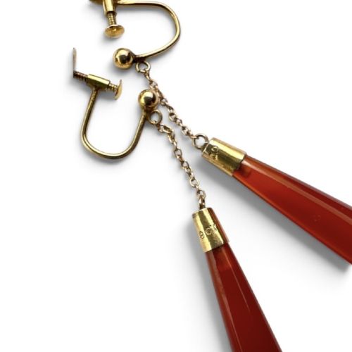 A pair of antique Edwardian drop earrings featuring long, polished teardrop-shaped carnelian stones suspended from delicate 9ct gold chains. View IV