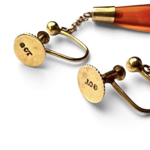 A pair of antique Edwardian drop earrings featuring long, polished teardrop-shaped carnelian stones suspended from delicate 9ct gold chains. View V