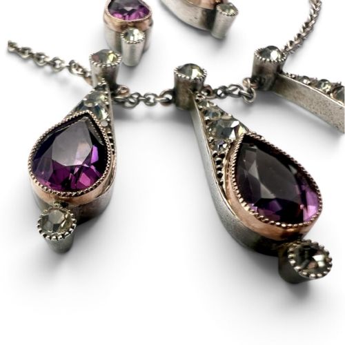 fig 1. An Art Deco jewellery set featuring a silver chain necklace with teardrop purple paste drops and matching drop earrings.