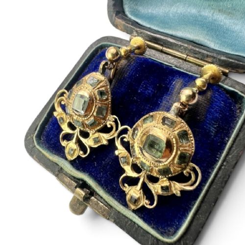 fig 1. A pair of ornate Georgian yellow gold drop earrings featuring central step-cut green gemstones surrounded by smaller accent stones and scrollwork flourishes.