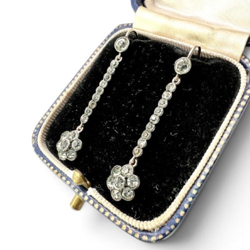 fig 1. A pair of antique drop earrings featuring a linear row of round faceted paste stones terminating in a flower cluster drop.