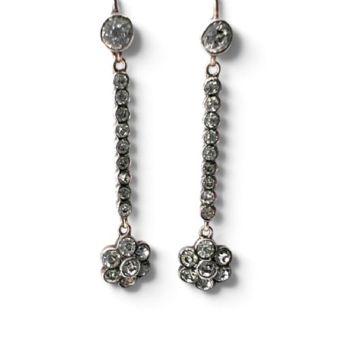 A pair of antique drop earrings featuring a linear row of round faceted paste stones terminating in a flower cluster drop. View V