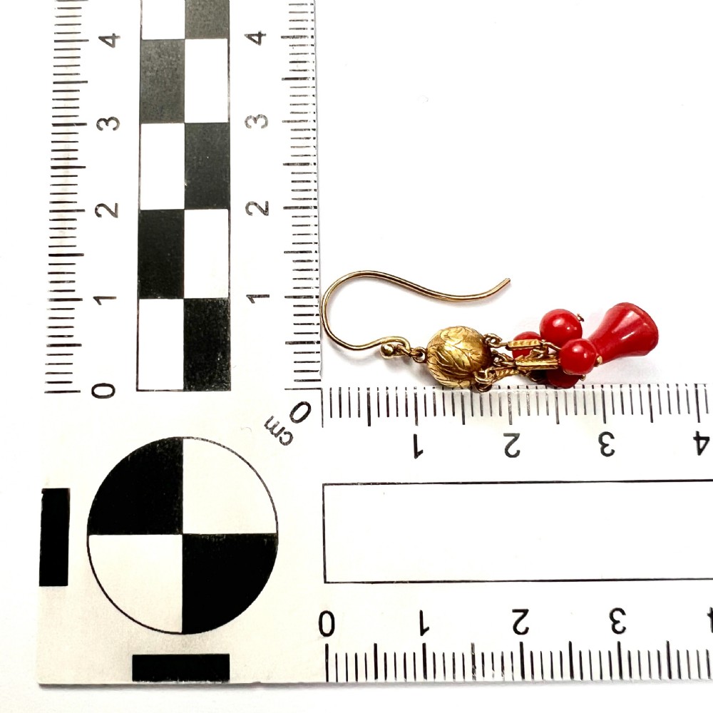 A pair of Victorian 15ct gold drop earrings featuring etched gold spheres suspended from wire hooks, with hanging gold bars, red coral beads, and bell-shaped coral drops. View V