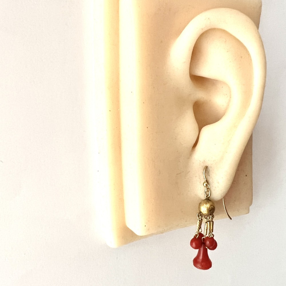 A pair of Victorian 15ct gold drop earrings featuring etched gold spheres suspended from wire hooks, with hanging gold bars, red coral beads, and bell-shaped coral drops. View VI