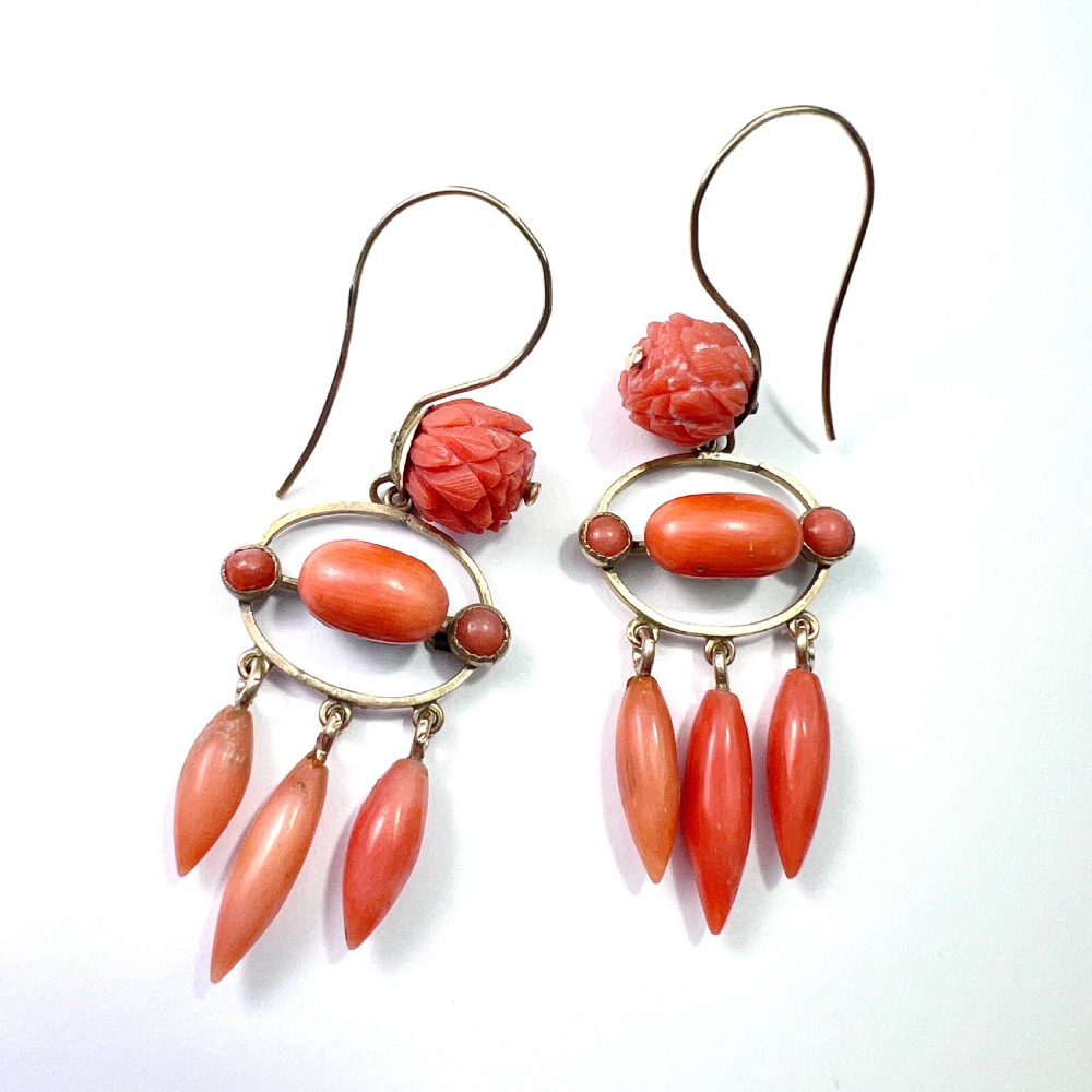 A pair of antique 9ct gold drop earrings featuring carved coral flowers, oval coral cabochons, and dangling coral torpedo drops. View II