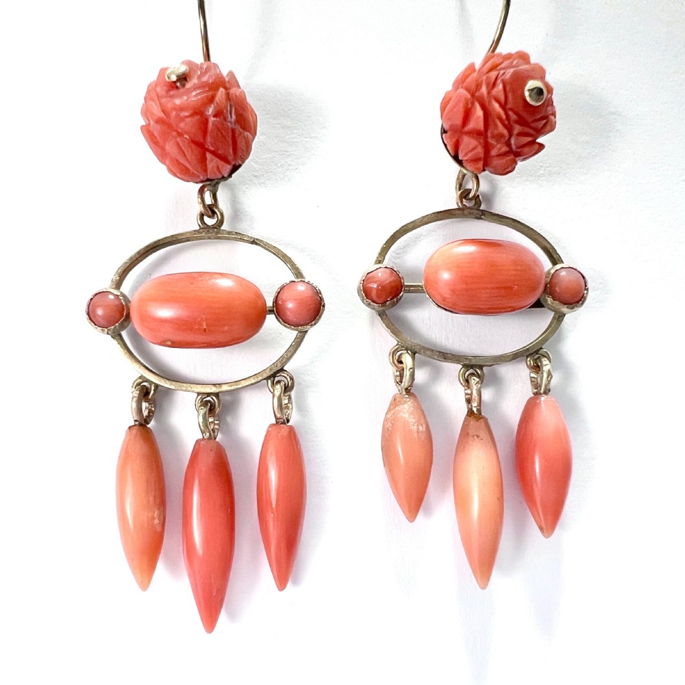 A pair of antique 9ct gold drop earrings featuring carved coral flowers, oval coral cabochons, and dangling coral torpedo drops. View III