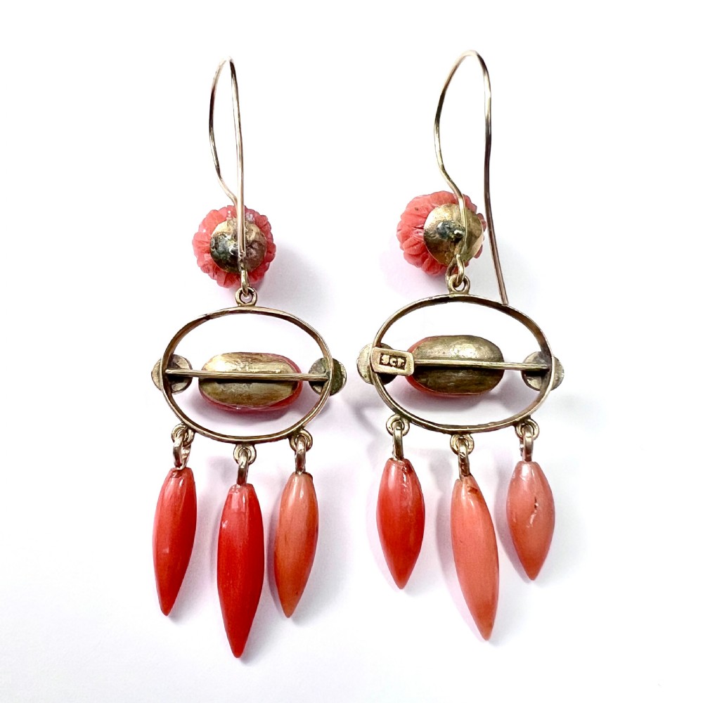 A pair of antique 9ct gold drop earrings featuring carved coral flowers, oval coral cabochons, and dangling coral torpedo drops. View IV
