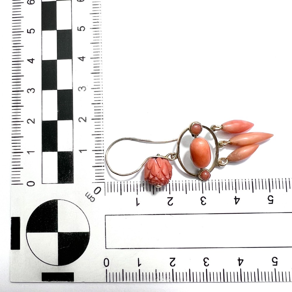 A pair of antique 9ct gold drop earrings featuring carved coral flowers, oval coral cabochons, and dangling coral torpedo drops. View VI