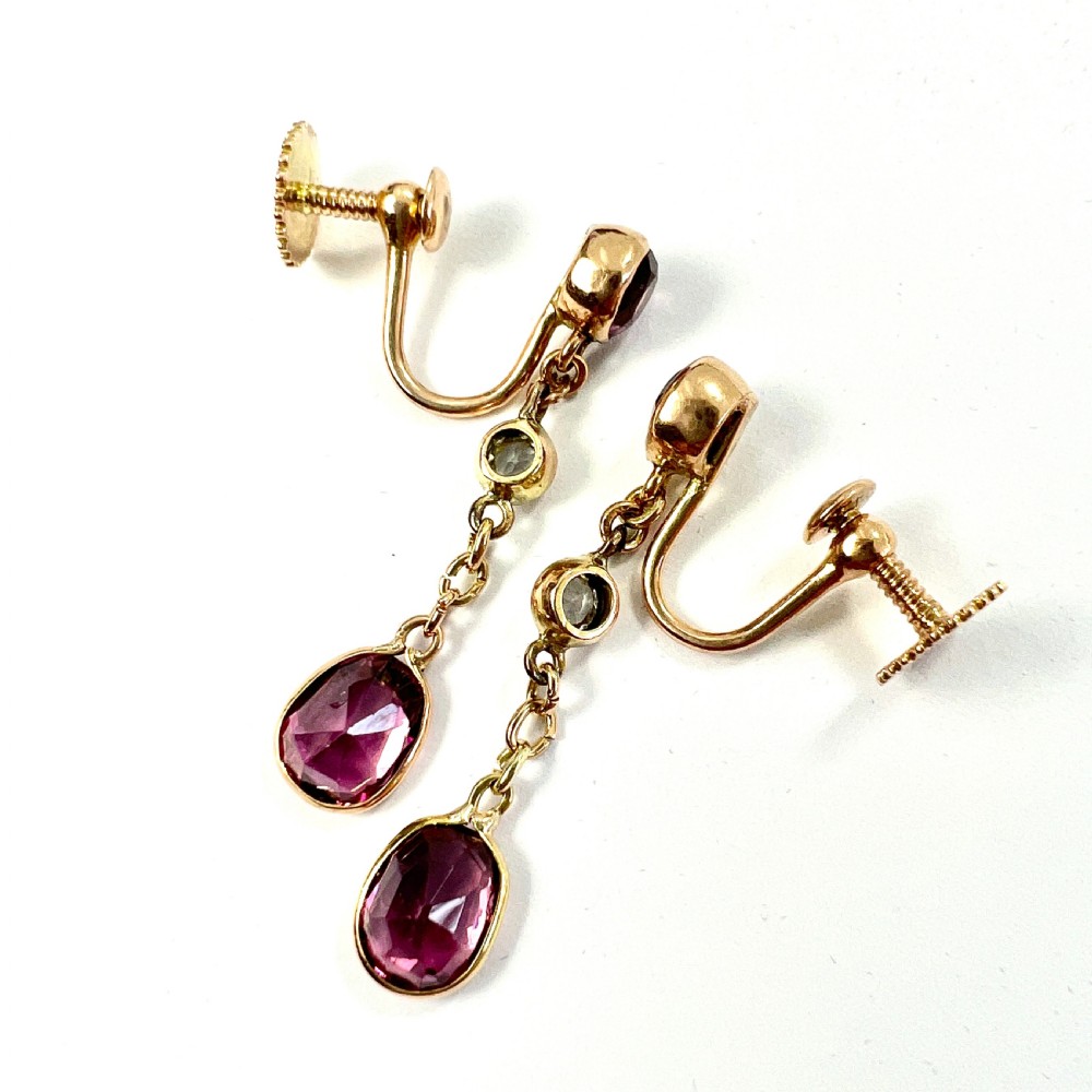 A pair of Edwardian 9ct yellow gold drop earrings set with faceted pink tourmalines and small round rock crystal accents. View IV