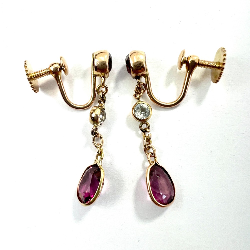 A pair of Edwardian 9ct yellow gold drop earrings set with faceted pink tourmalines and small round rock crystal accents. View V