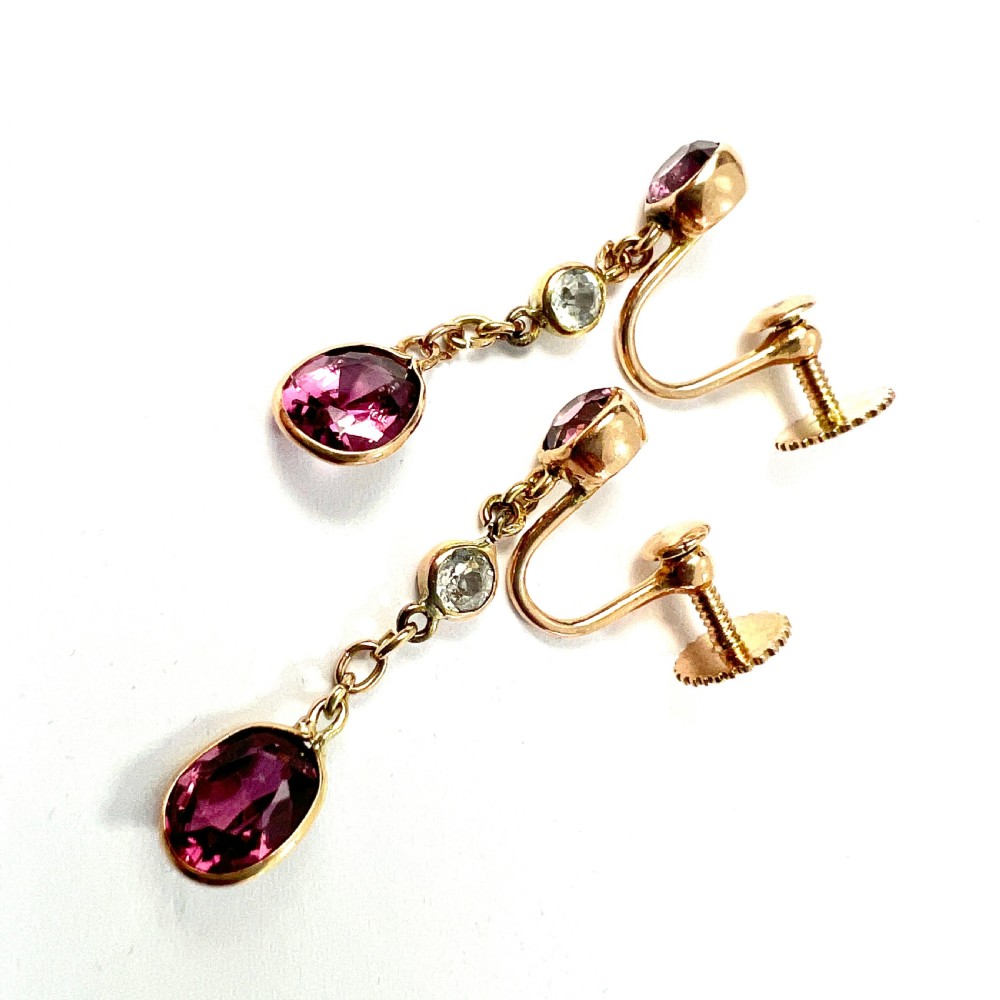 A pair of Edwardian 9ct yellow gold drop earrings set with faceted pink tourmalines and small round rock crystal accents. View VII