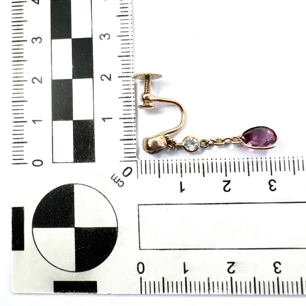 A pair of Edwardian 9ct yellow gold drop earrings set with faceted pink tourmalines and small round rock crystal accents. View VIII