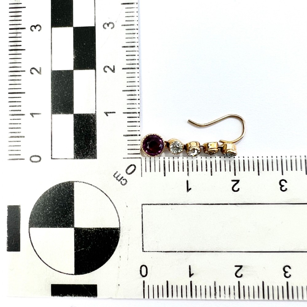 A pair of Edwardian 9ct yellow gold drop earrings with linear clear stones and round purple amethyst terminals set in a green fitted display box. View V