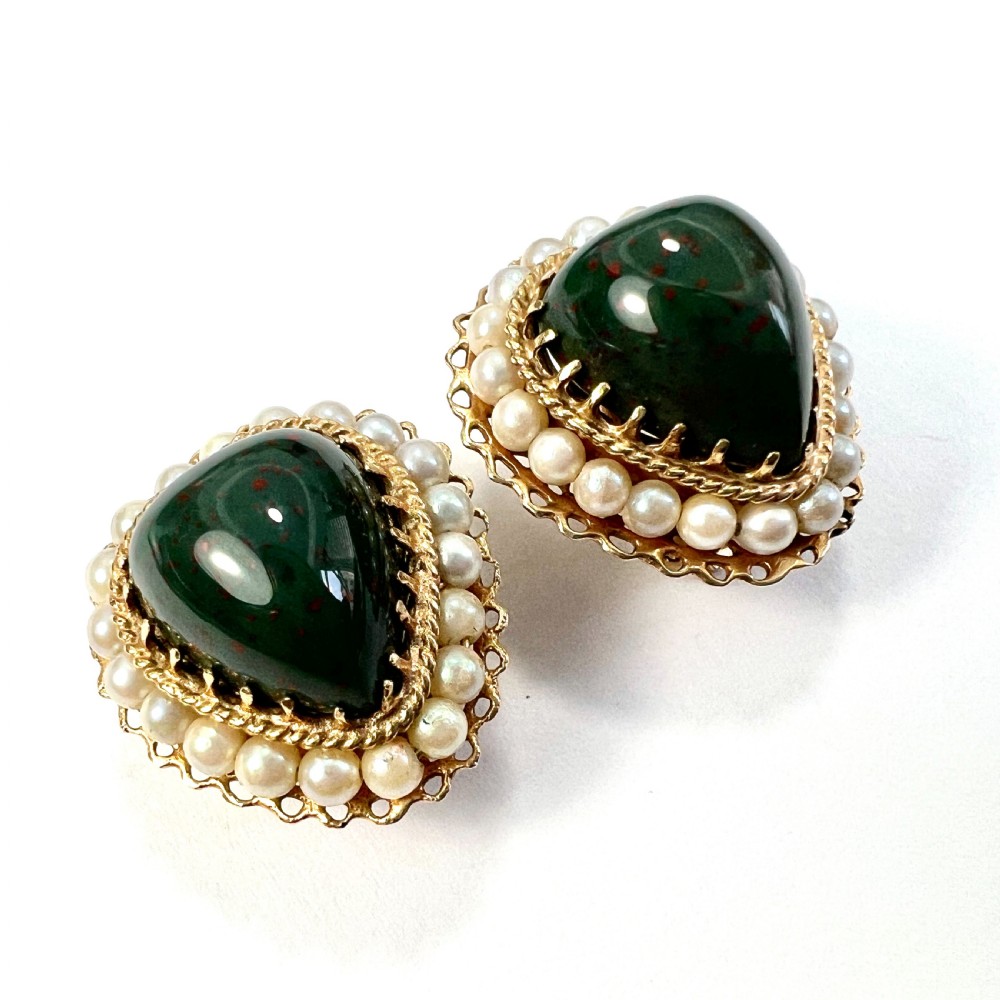 A pair of heart-shaped dark green bloodstone cabochon clip earrings framed by 14ct gold filigree and a halo of white seed pearls. View II