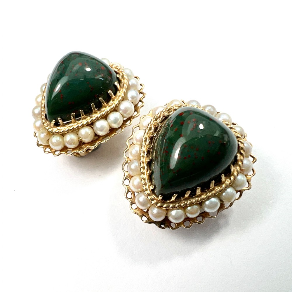 A pair of heart-shaped dark green bloodstone cabochon clip earrings framed by 14ct gold filigree and a halo of white seed pearls. View III