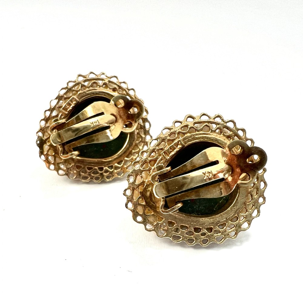 A pair of heart-shaped dark green bloodstone cabochon clip earrings framed by 14ct gold filigree and a halo of white seed pearls. View V
