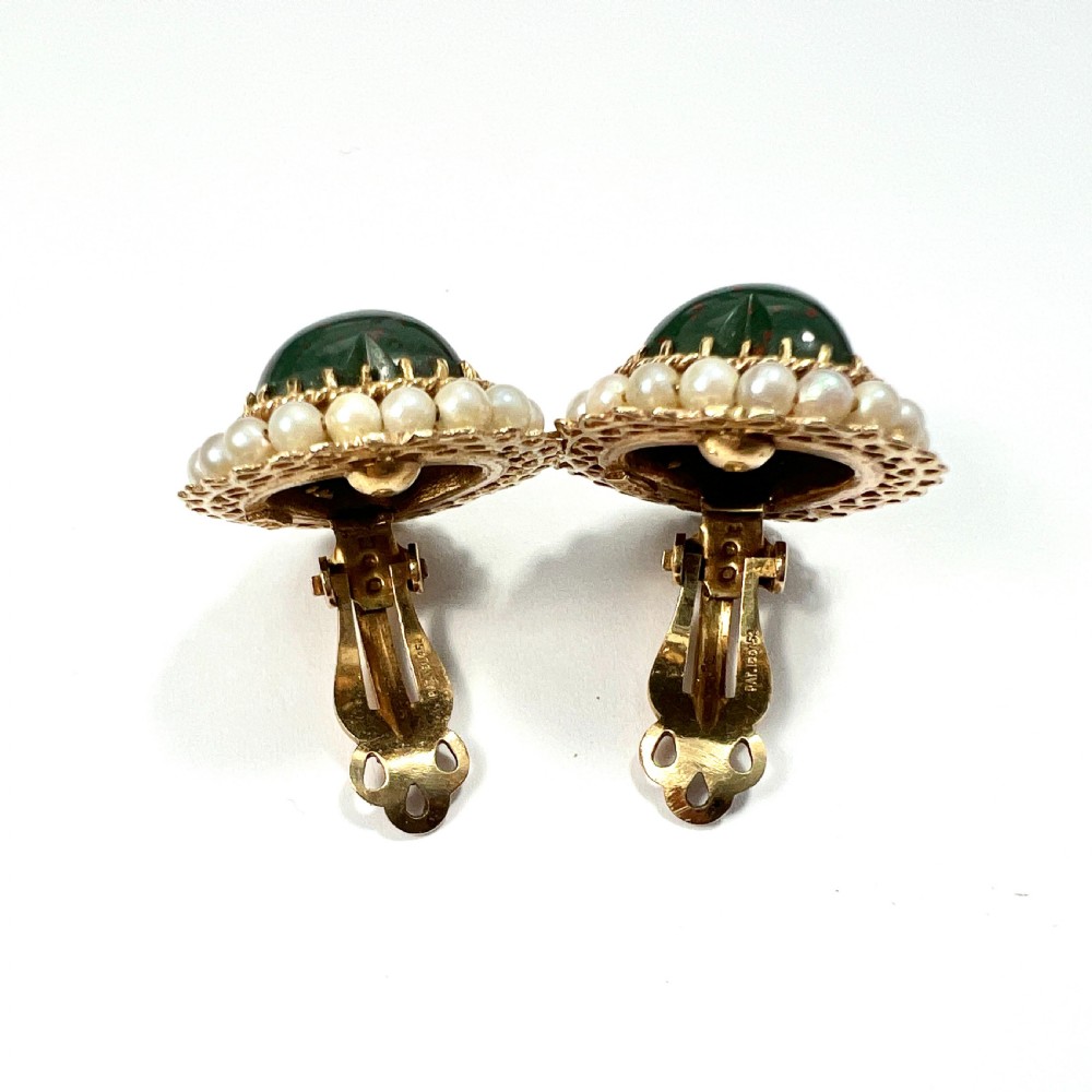 A pair of heart-shaped dark green bloodstone cabochon clip earrings framed by 14ct gold filigree and a halo of white seed pearls. View VI