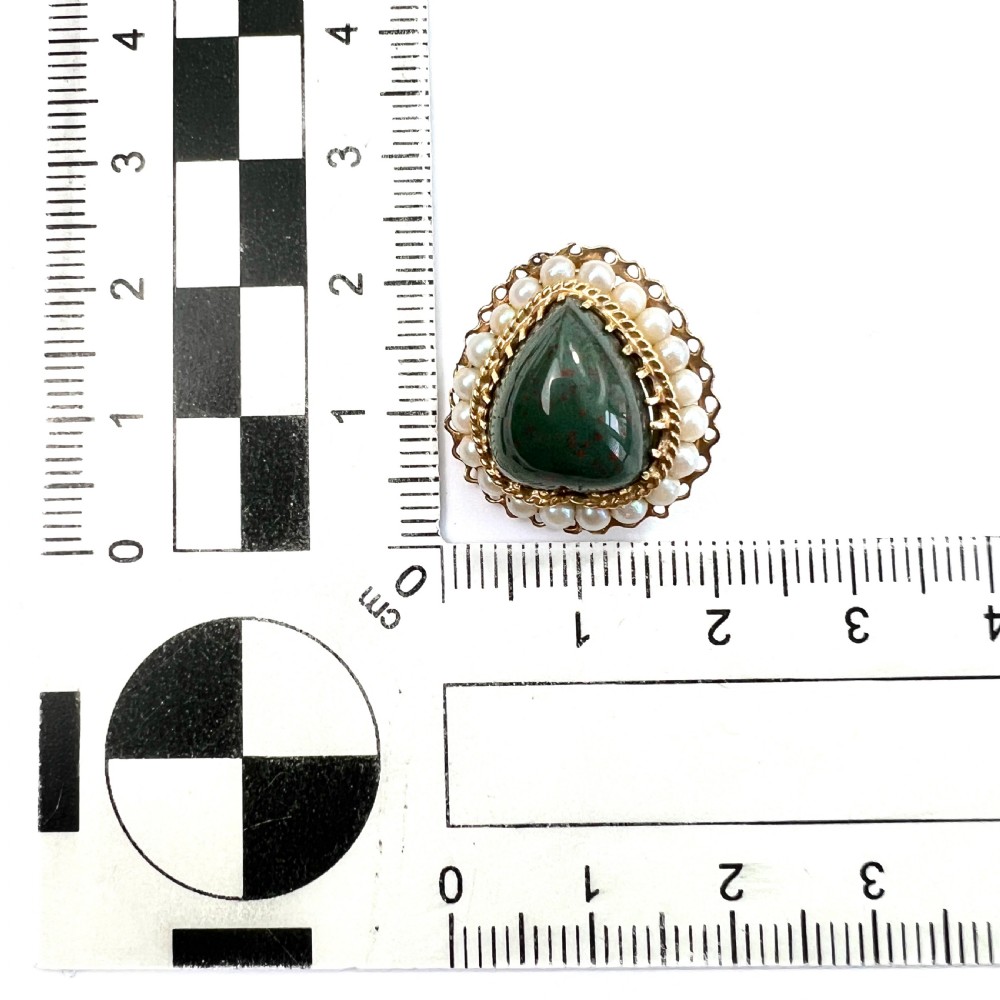 A pair of heart-shaped dark green bloodstone cabochon clip earrings framed by 14ct gold filigree and a halo of white seed pearls. View VII