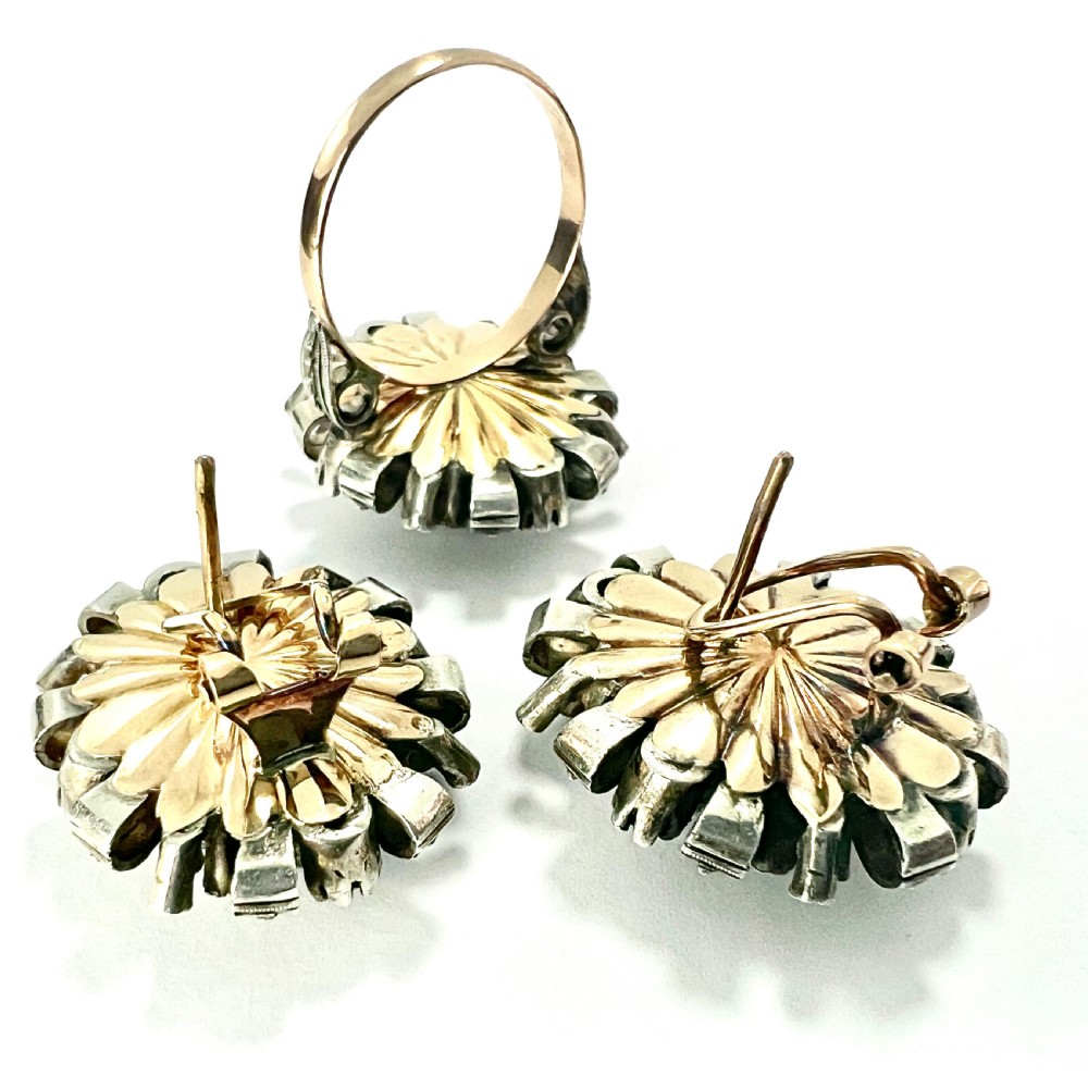A three-piece jewellery suite featuring a oval purple gemstone ring and matching cluster earrings in silver and gold settings. View IV