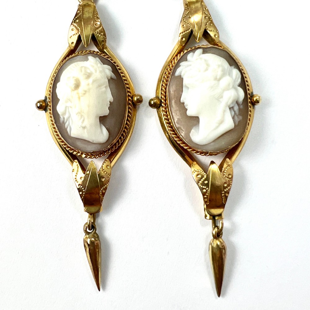A pair of Victorian drop earrings featuring oval carved shell cameos set in pinchbeck frames with engraved leaf details and 9ct gold ear wires. View II