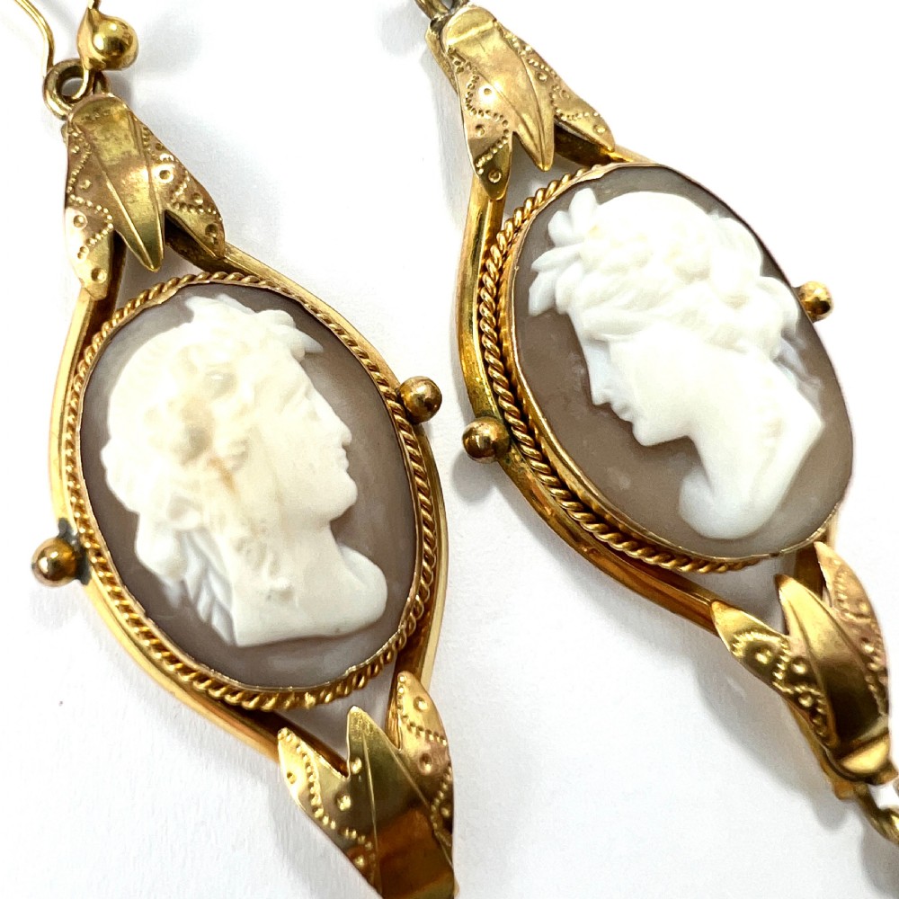 A pair of Victorian drop earrings featuring oval carved shell cameos set in pinchbeck frames with engraved leaf details and 9ct gold ear wires. View III