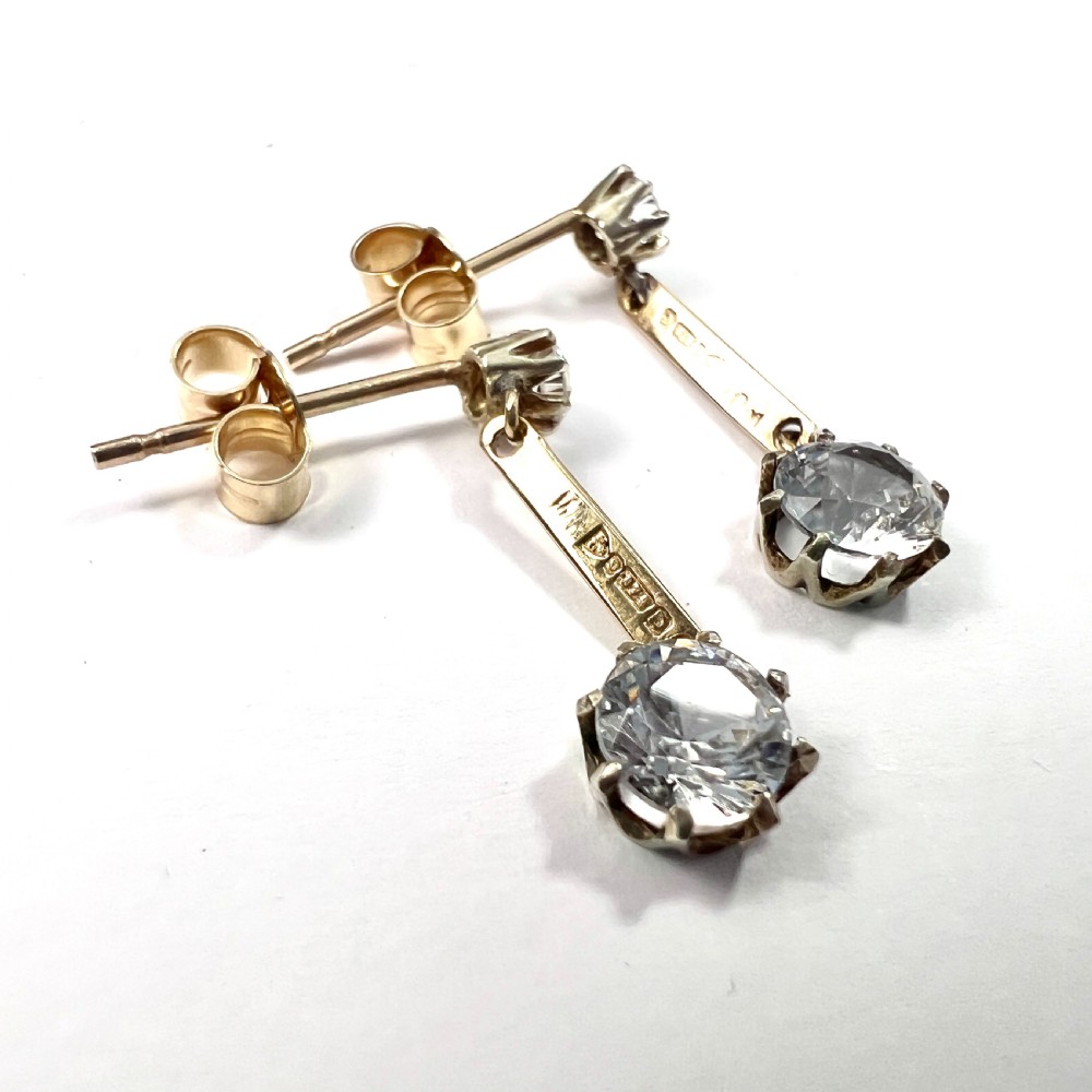 A pair of 9ct yellow gold drop earrings featuring round white zircons held in claw settings. View III