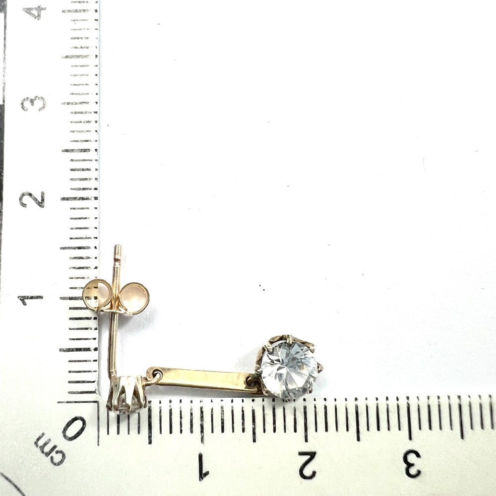 A pair of 9ct yellow gold drop earrings featuring round white zircons held in claw settings. View VII